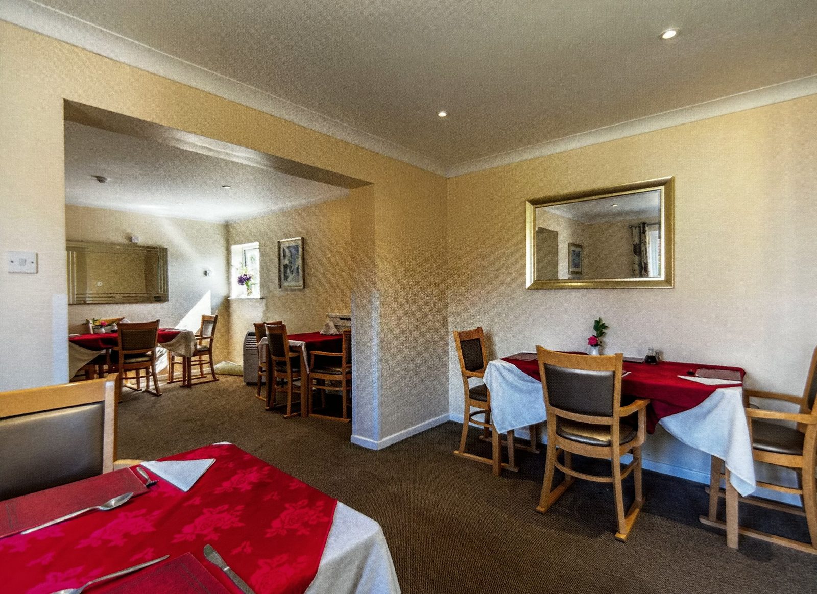 The dining room at Stronvar, tables laid with red cloths and napkins